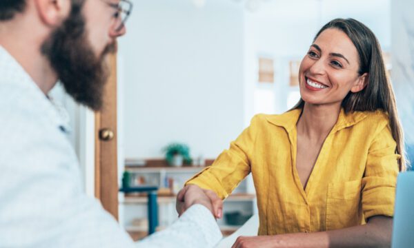 woman smiling and shaking hands with man