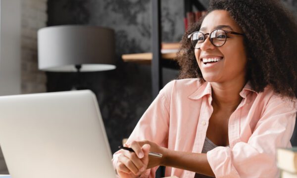 woman smiling and looking above computer screen